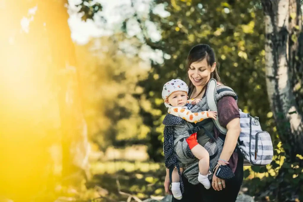 “Mother using ergonomic baby carrier for newborn.”