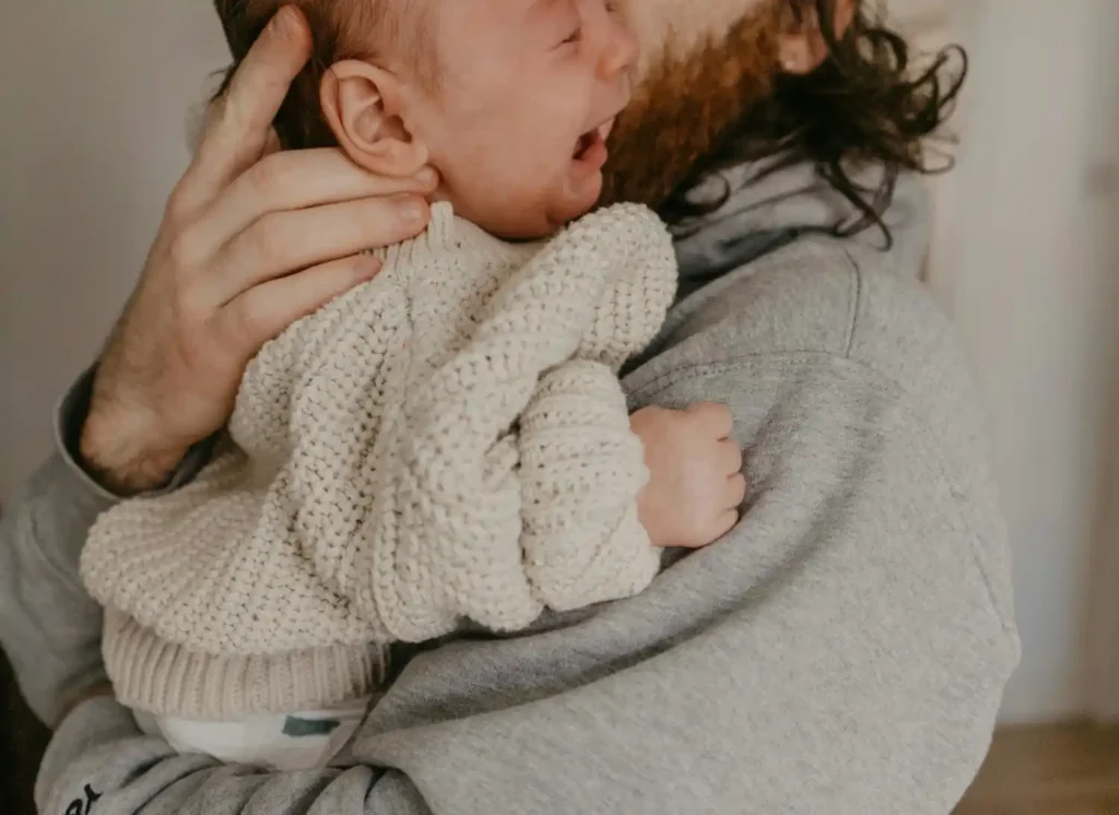 new parents holding newborn baby in early days after birth