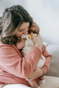 mother burping newborn baby after feeding