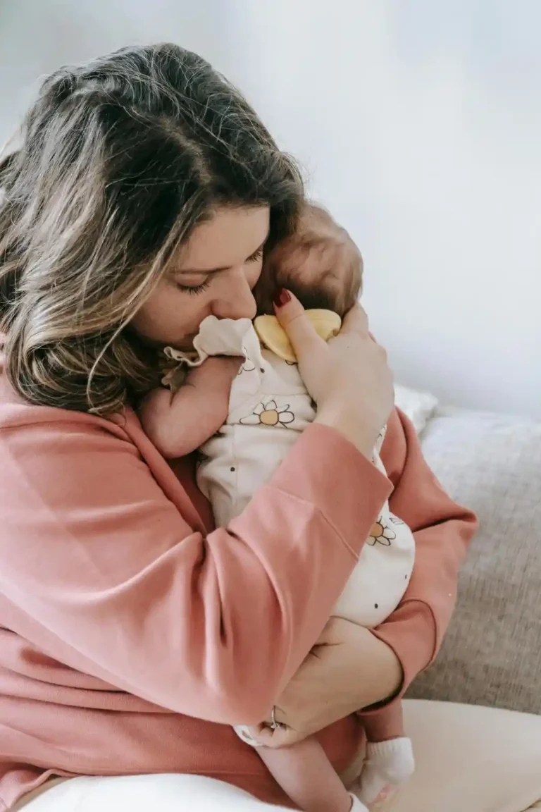 mother burping newborn baby after feeding