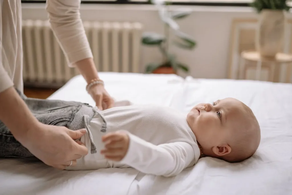 newborn baby showing signs of gas discomfort while being comforted by parent